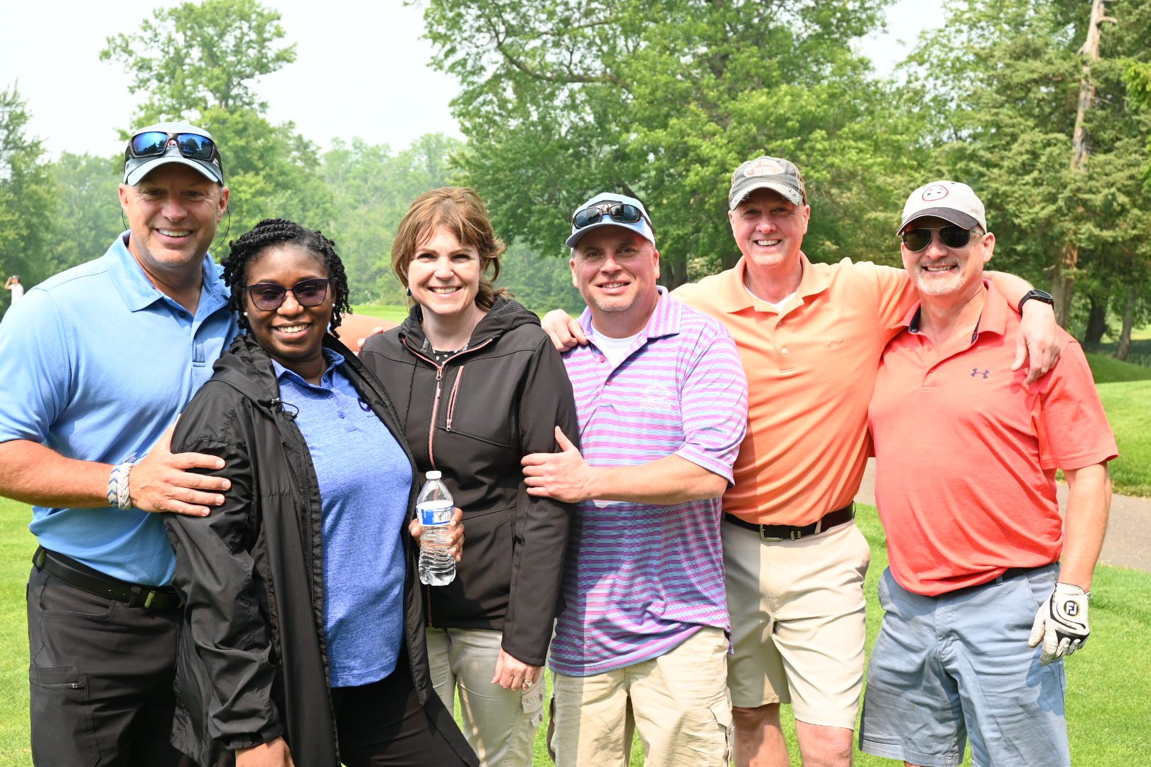 Group of six people posing at the Golf Tournament